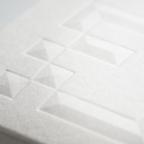 Close of a folded box lid produced with alternative sustainable material Gmund Hemp with an embossed design